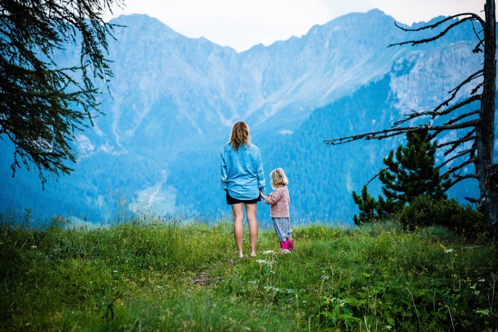 Mother and child looking out to a view of mountains.