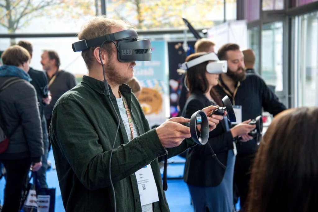 A group of people use virtual reality equipment in a public space.